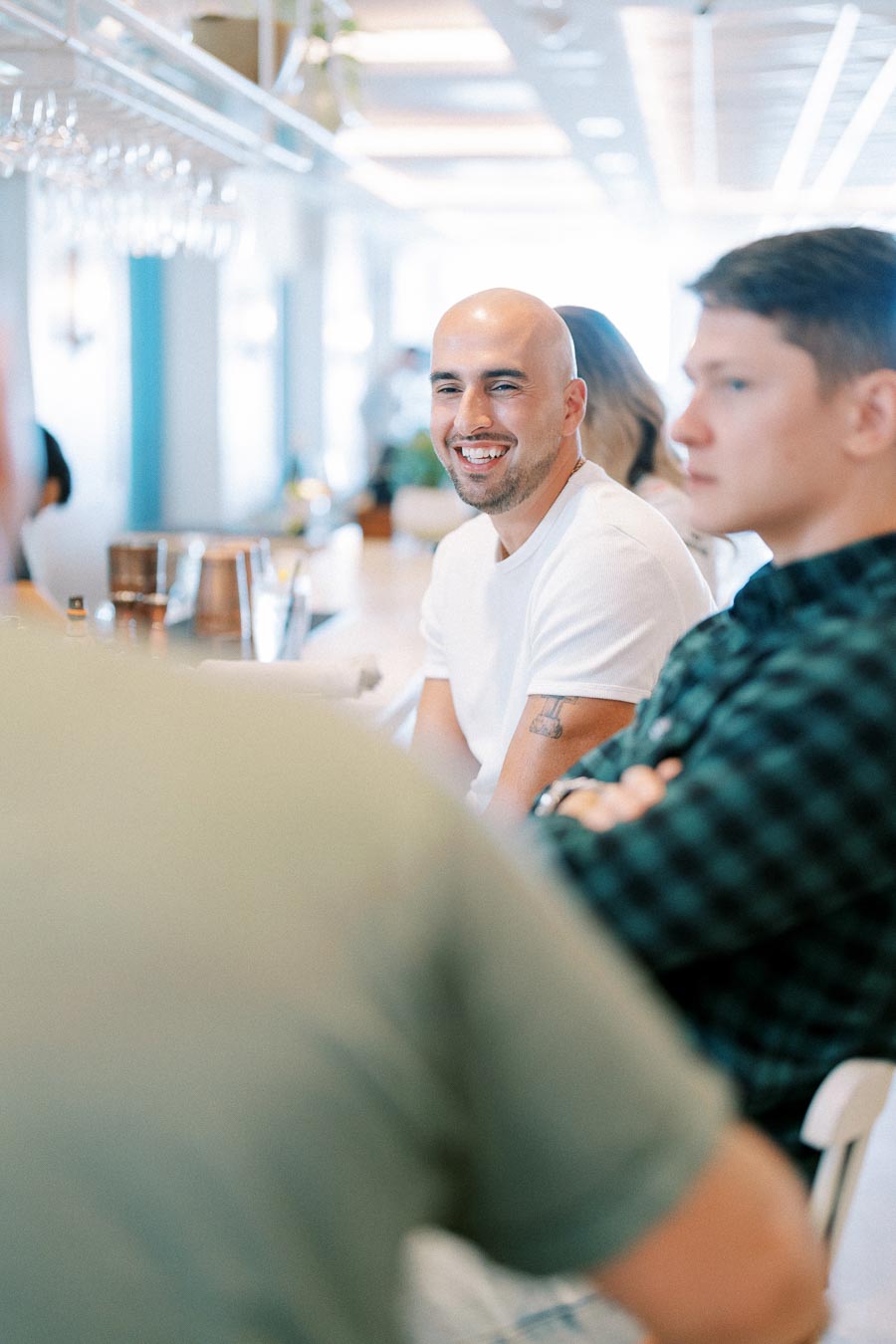 Group of people enjoying a relaxed gathering in a bright, modern café setting.