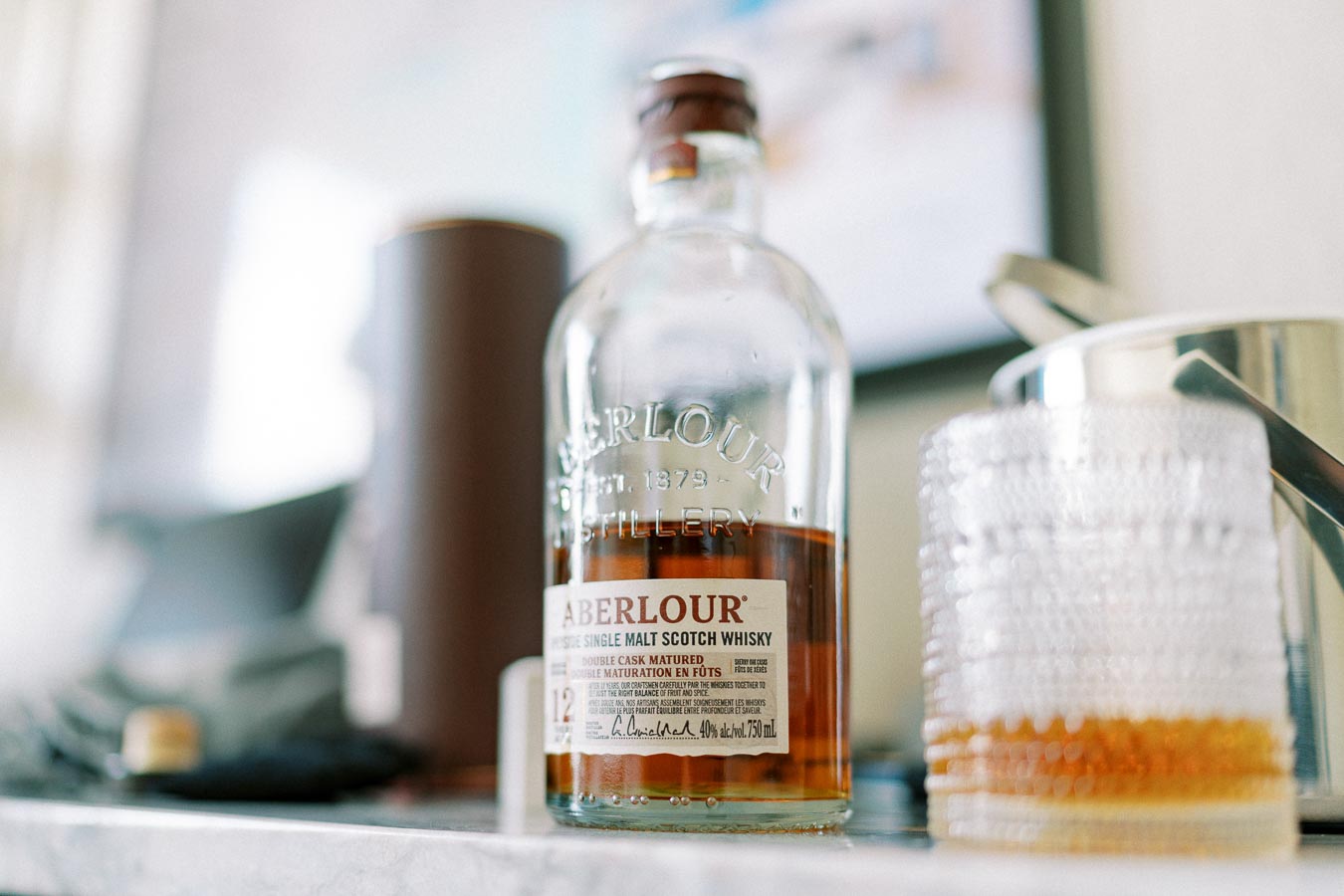 Close-up of Aberlour 12-Year-Old Single Malt Scotch Whisky bottle on a kitchen counter with a glass beside it, showcasing premium whisky beverage.