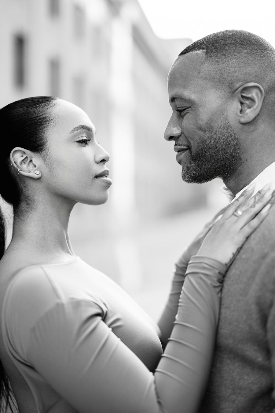A couple shares an intimate moment, gazing into each other's eyes in a black and white photograph.