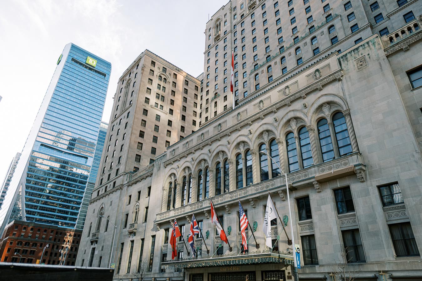 The historic Fairmont Royal York Hotel in Toronto, with the modern TD Tower visible in the background, showcasing a blend of architectural styles.