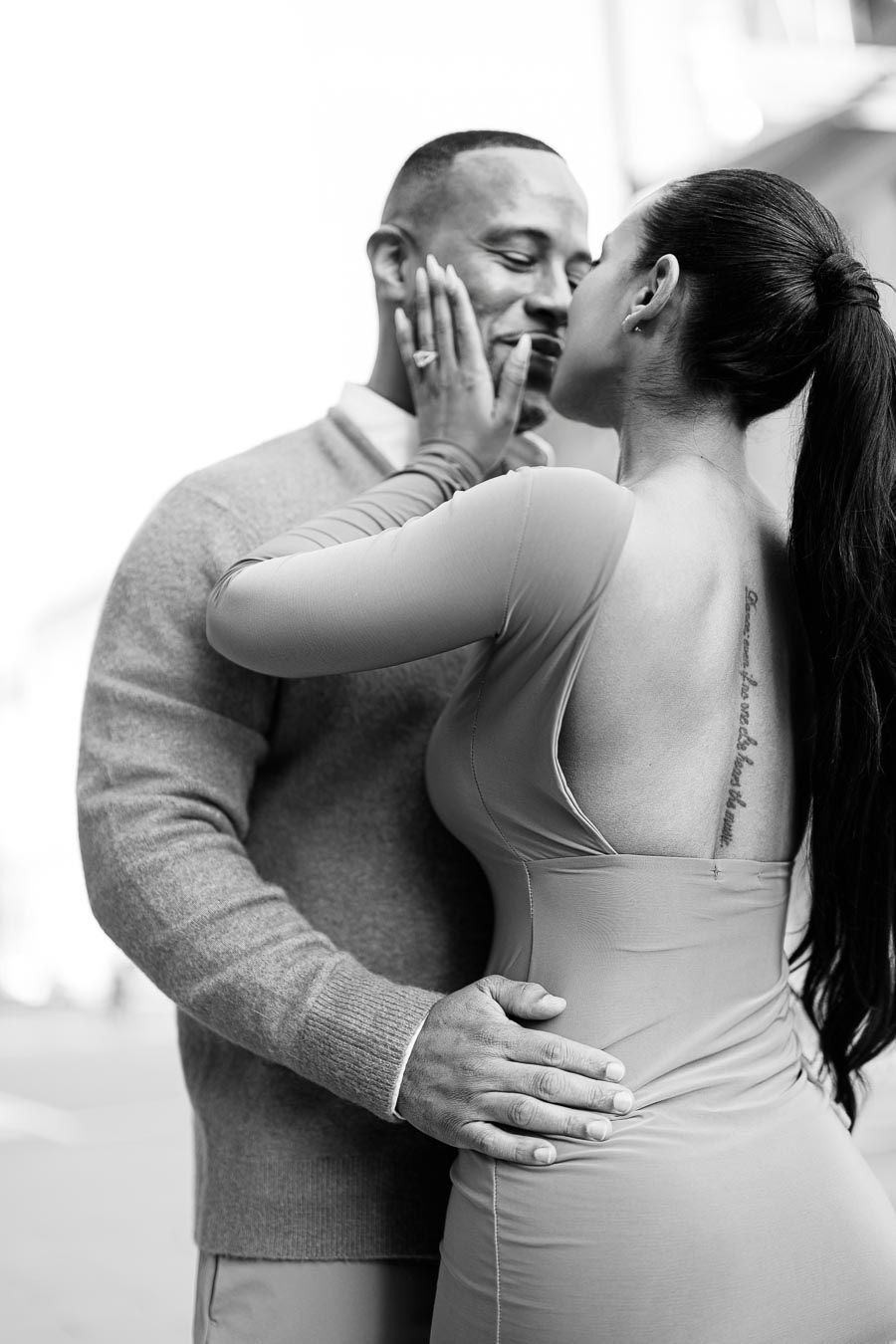 A couple shares an intimate moment in a black and white photograph, highlighting their affection and connection.