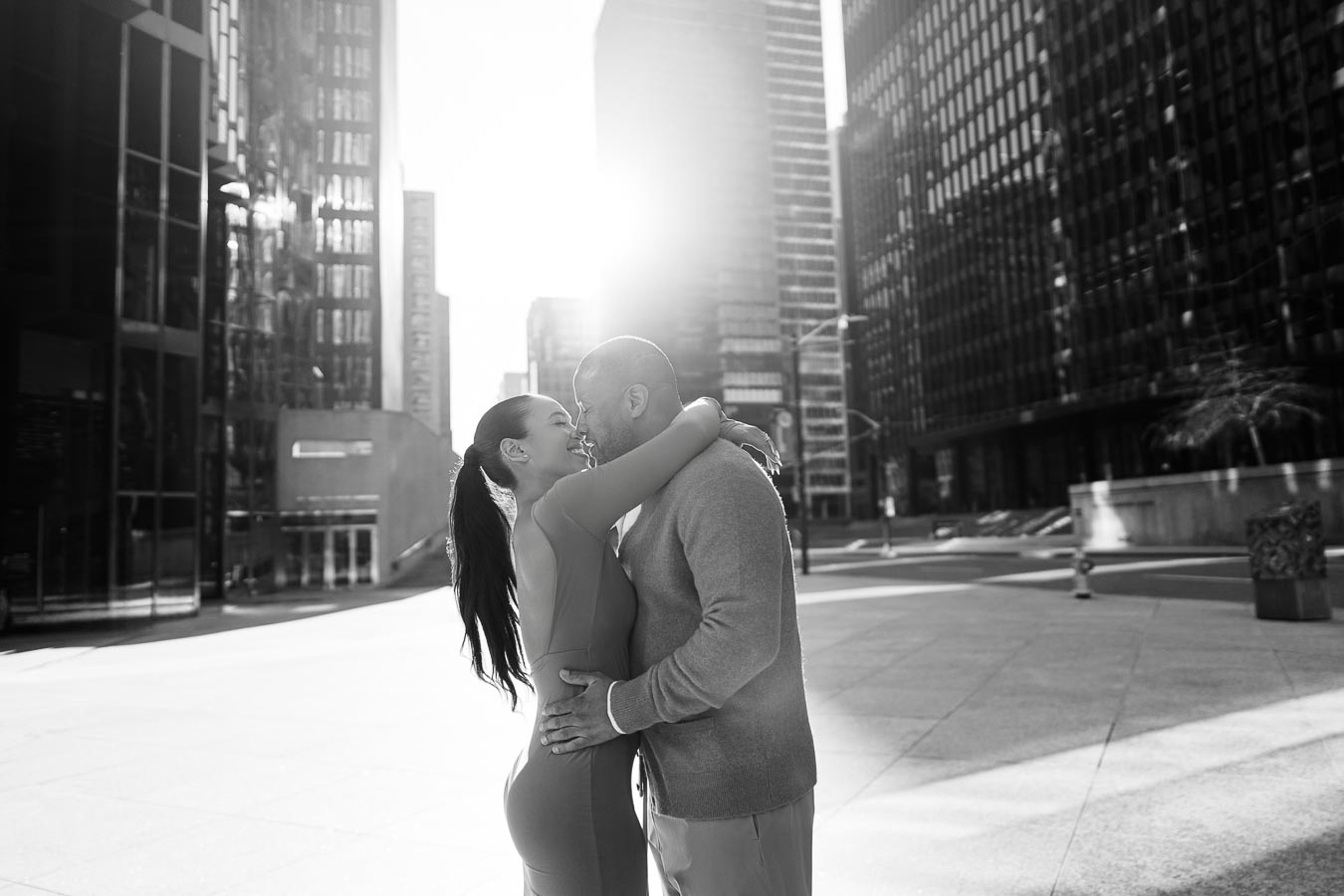 Romantic black and white photo of DeVon Franklin and Maria Castillo embracing in downtown Toronto with skyscrapers in the background