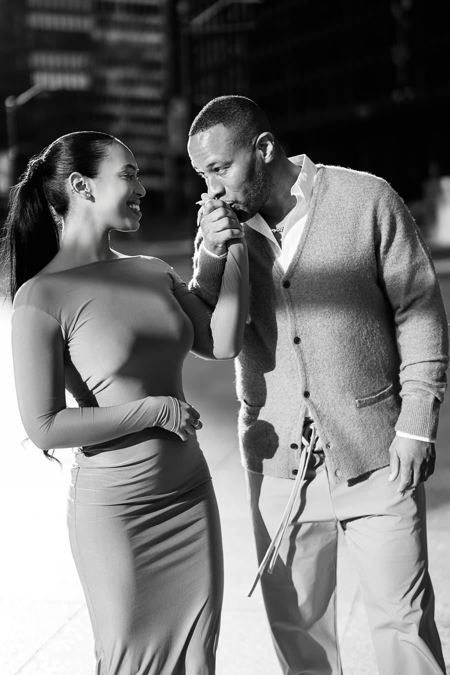 DeVon Franklin kissing Maria Castillo’s hand during a romantic black and white engagement shoot in downtown Toronto