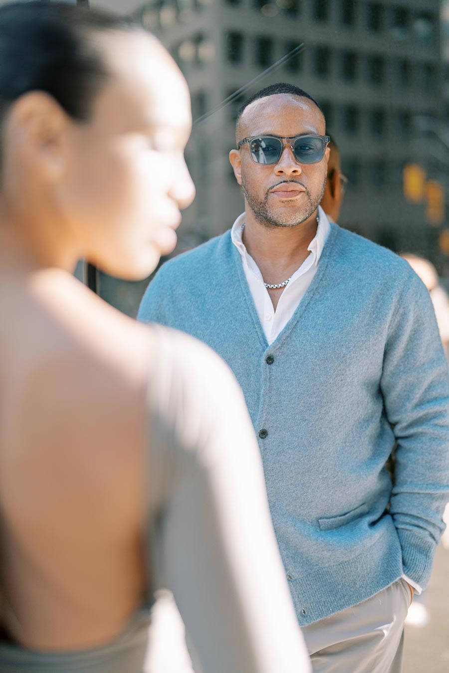 DeVon Franklin wearing sunglasses, looking at Maria Castillo during downtown Toronto engagement session
