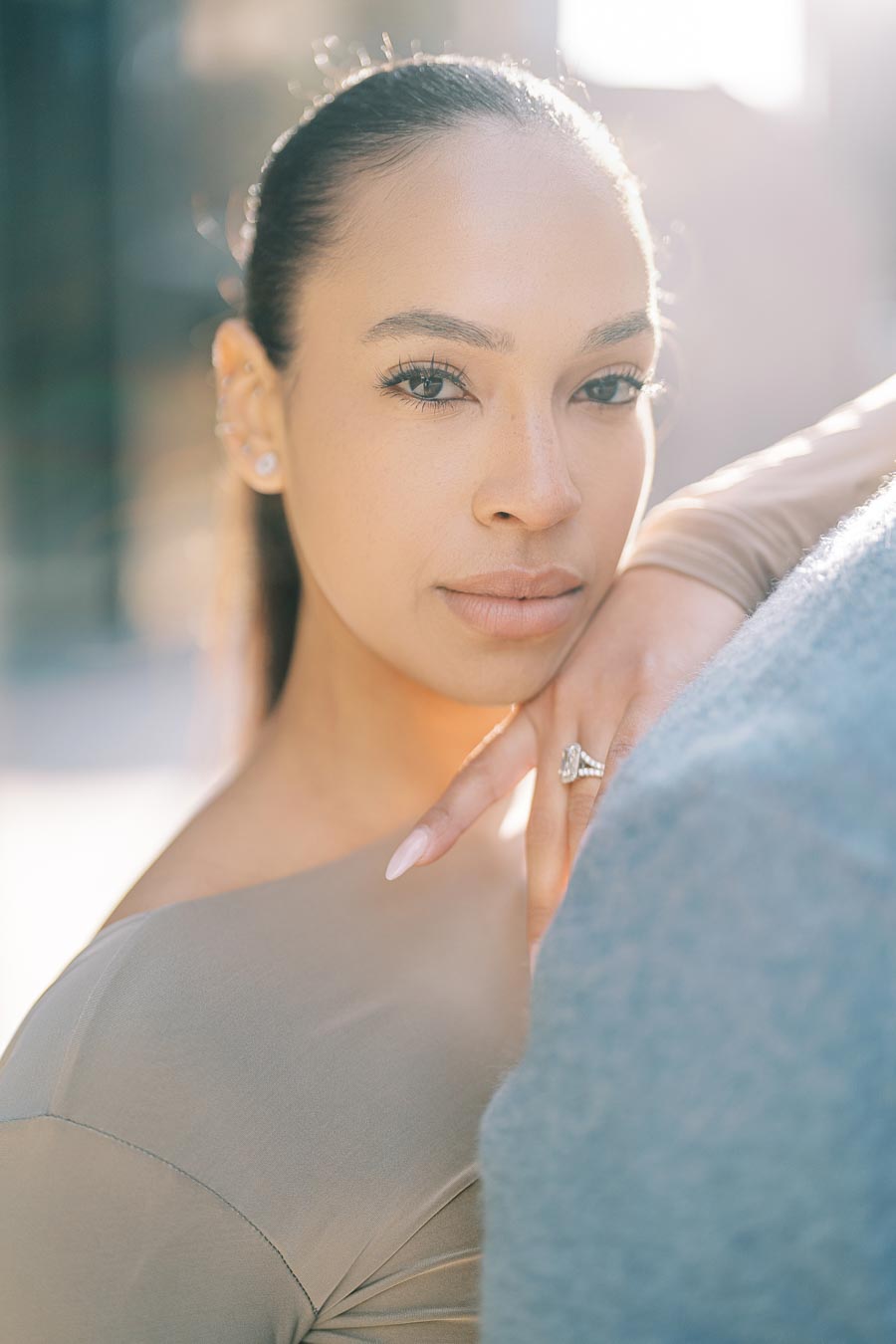 Maria Castillo looking at the camera with her hand resting on DeVon Franklin’s shoulder during their downtown Toronto engagement shoot