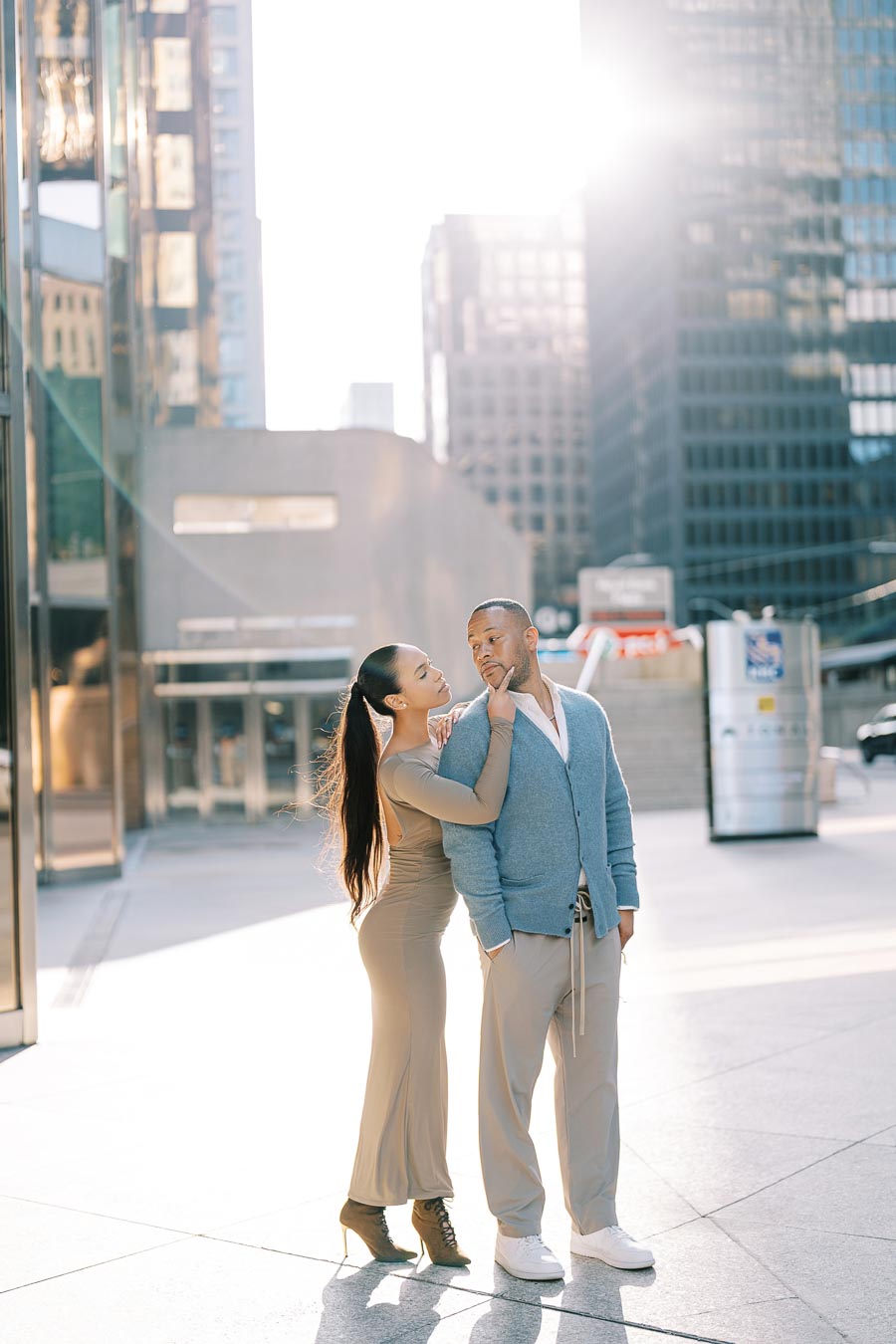 Full-body portrait of DeVon Franklin and Maria Castillo during their downtown Toronto engagement shoot with sunlit skyscrapers in the background
