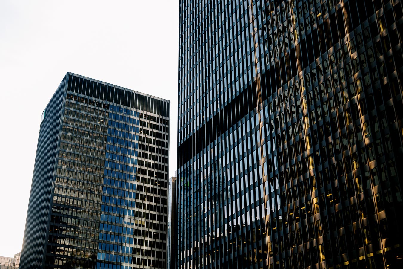 A view of modern skyscrapers with reflective glass facades, showcasing the architectural design and urban landscape.