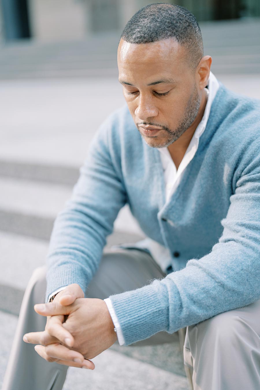 Thoughtful portrait of DeVon Franklin sitting on downtown Toronto steps during engagement photoshoot