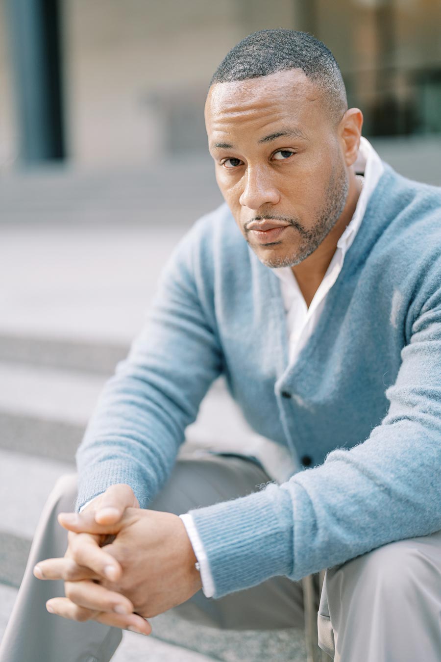 Close-up of groom-to-be sitting on granite steps in downtown Toronto looking confidently at the camera