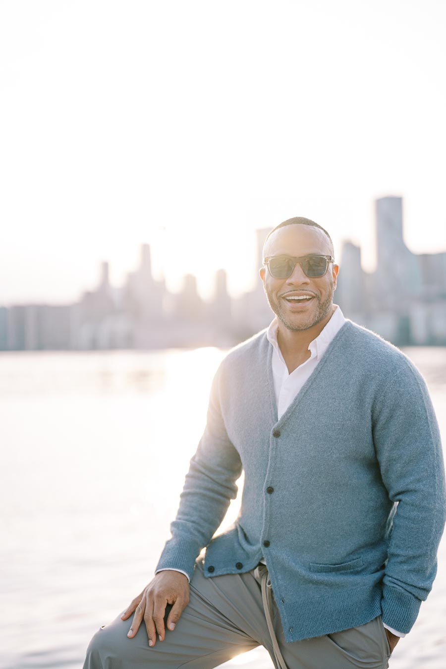 Groom-to-be smiling in sunglasses at Toronto waterfront engagement session during golden hour