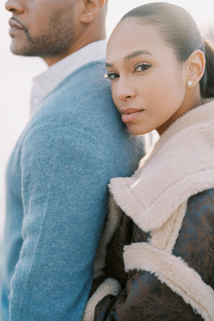 Close-up of engaged woman leaning on fiancé’s back during Toronto waterfront photoshoot