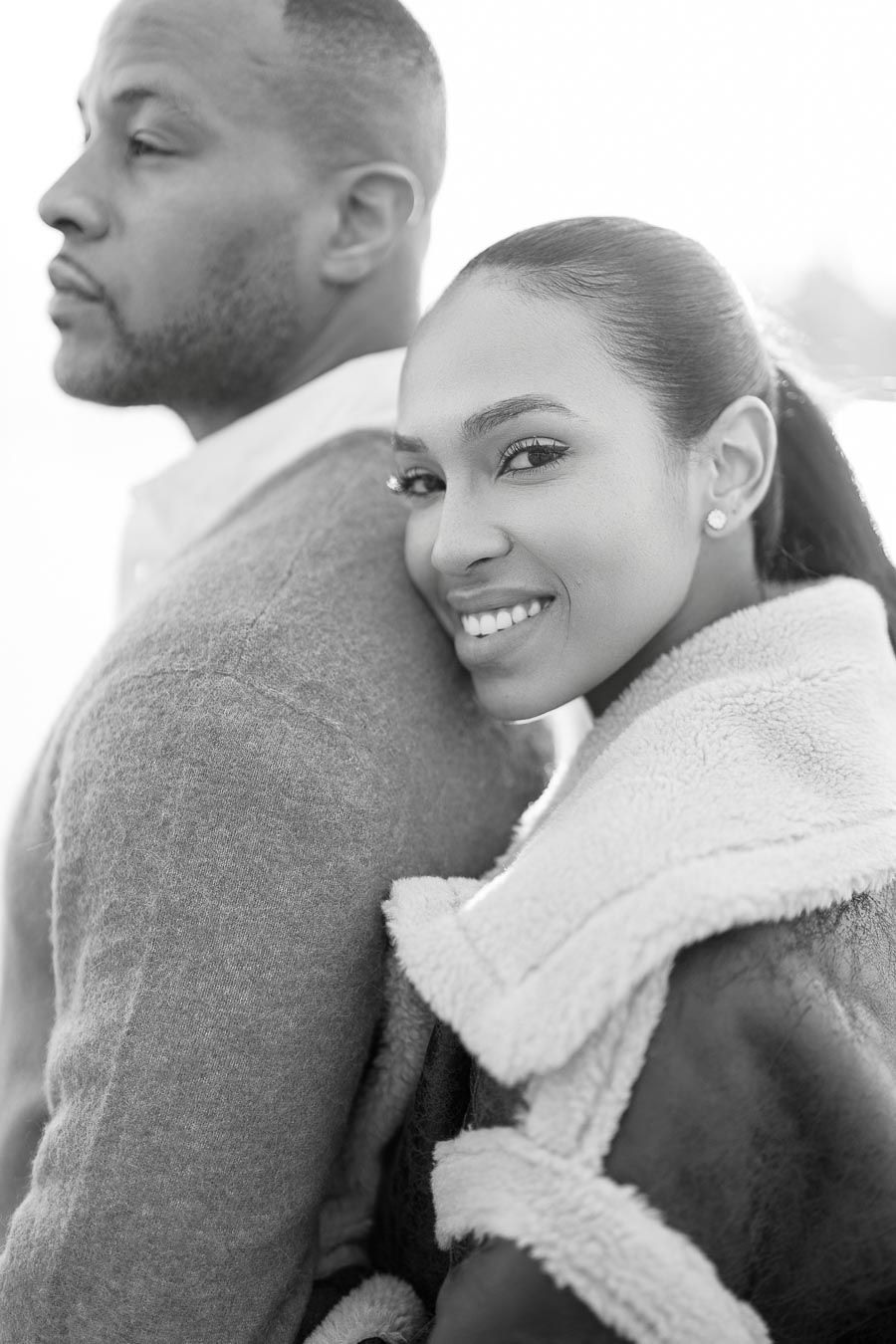 Woman smiling while leaning on partner’s back during Toronto engagement session