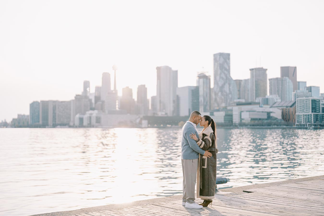 Romantic couple during engagement session on Toronto waterfront with skyline view