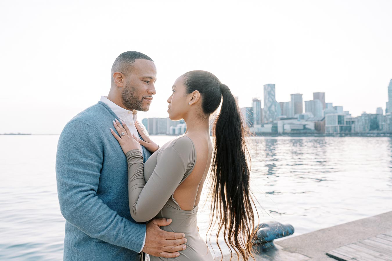DeVon Franklin and Maria Castillo facing each other during engagement session by the Toronto waterfront