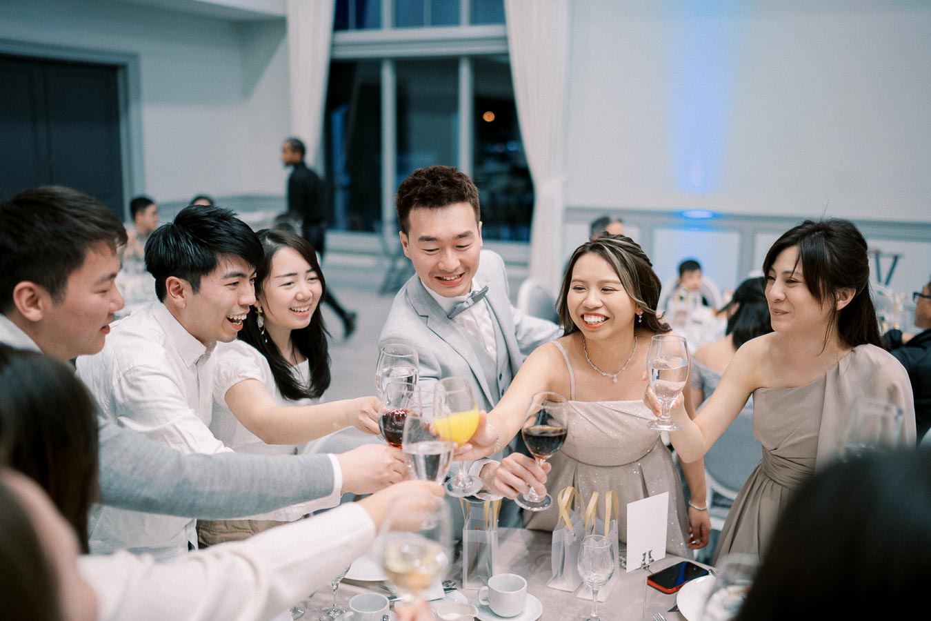 A group of people joyfully toasting with wine glasses at an elegant event, showcasing celebration and camaraderie in a formal setting.
