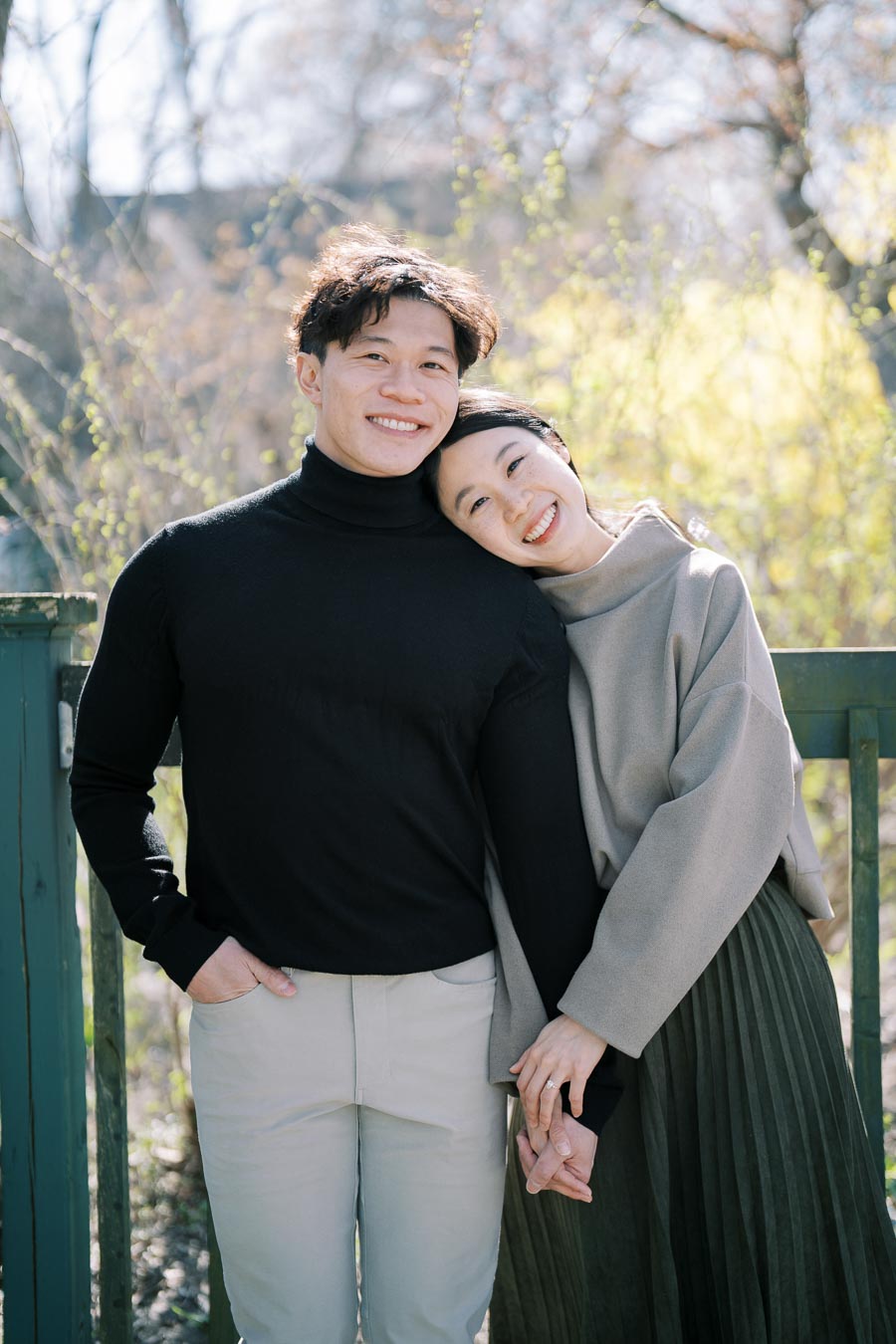 A happy couple enjoying a sunny day outdoors, smiling and holding hands.