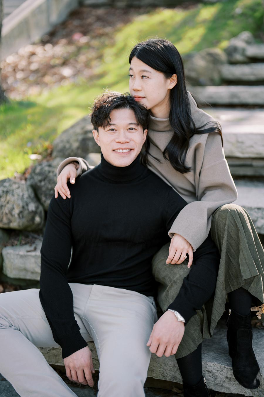 A couple enjoying a moment together on stone steps in a park.