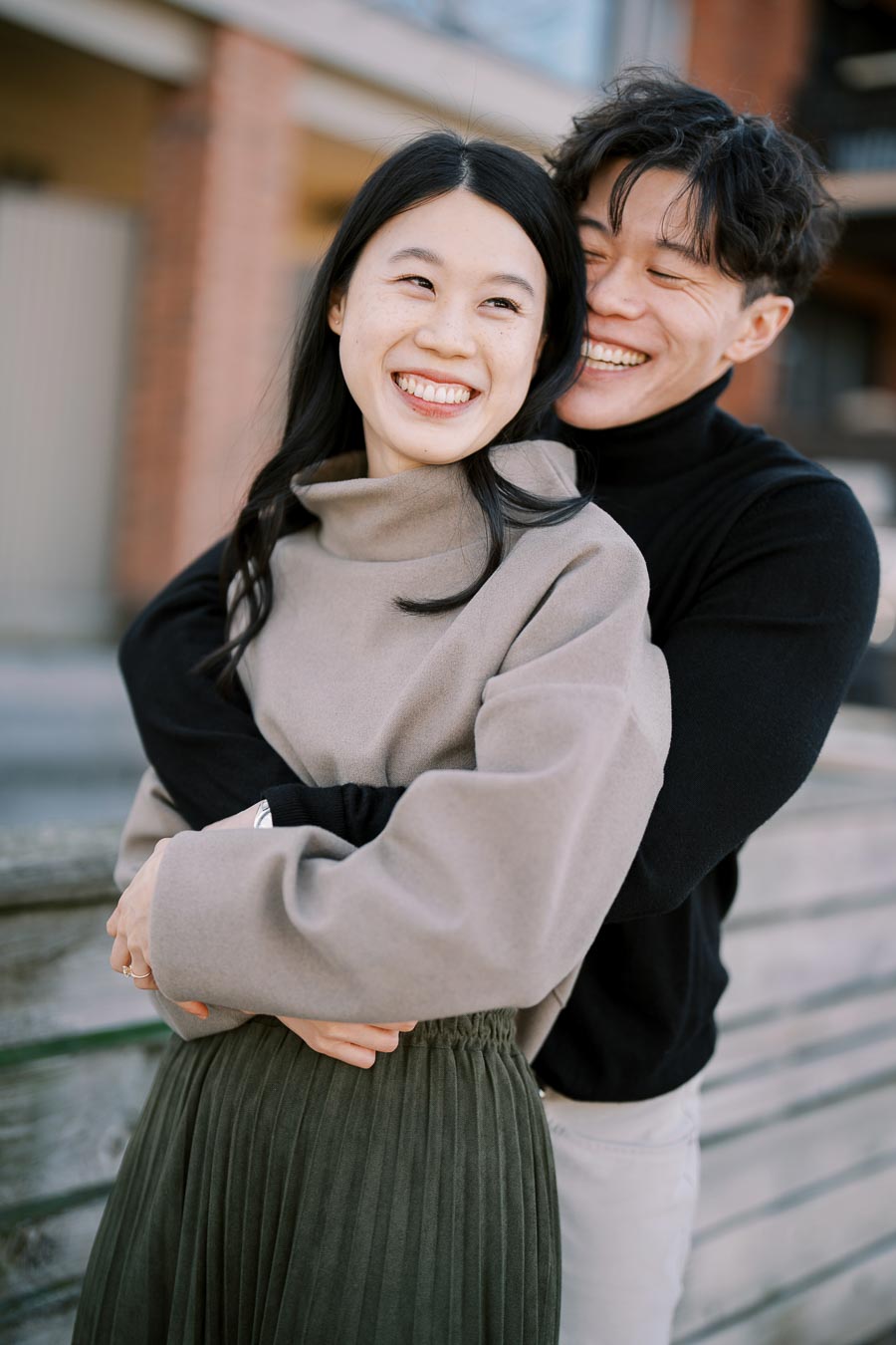 A joyful couple embraces outdoors, sharing a moment of happiness.