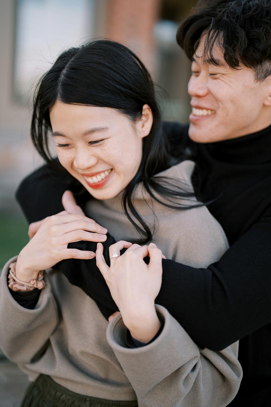 A joyful couple embracing and smiling outdoors, showcasing a moment of happiness and affection.