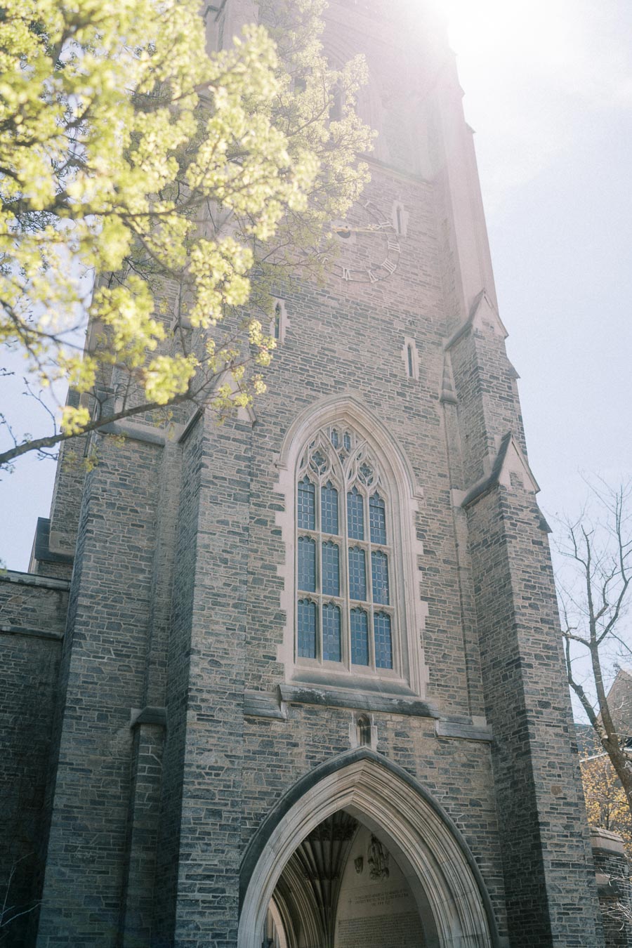 Gothic-style stone building at the University of Toronto with a large arched window.