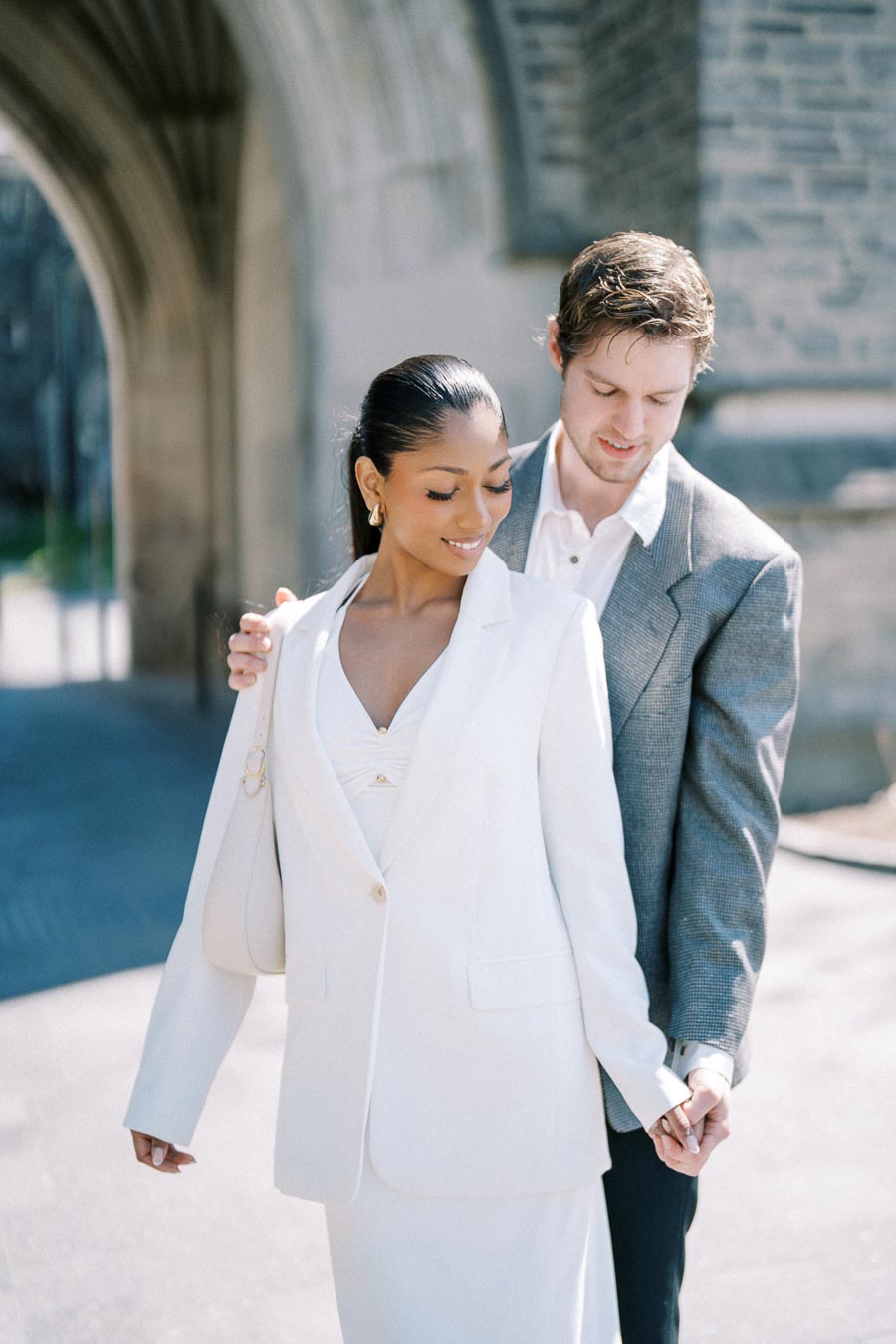 Couple in formal attire posing together outdoors at the University of Toronto.