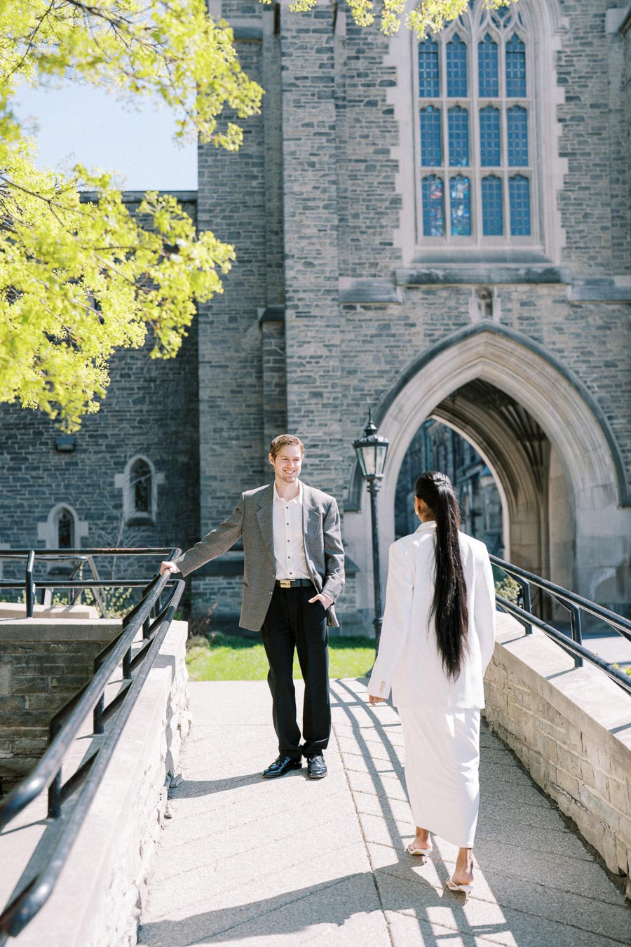 Couple standing on a pathway at the University of Toronto during an engagement session.