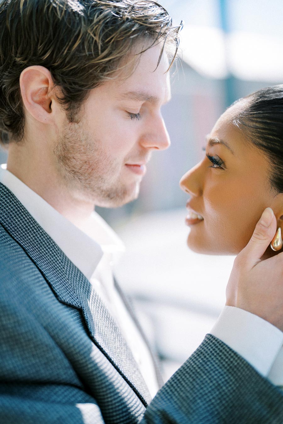 Close-up portrait of a couple gazing into each other's eyes, with soft expressions and natural light.