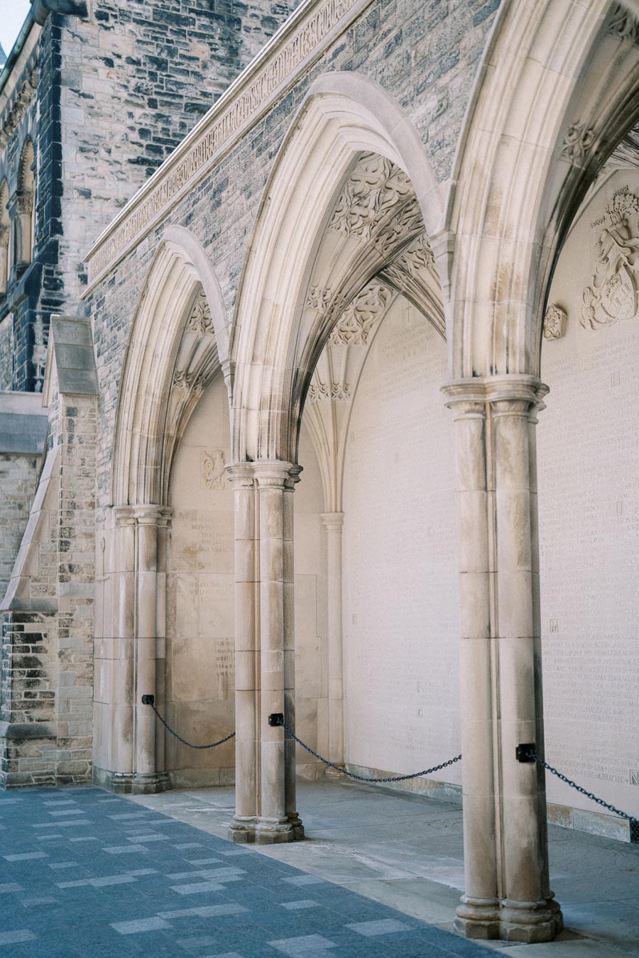 Ornate stone arches and columns of historical building exterior, showcasing intricate architectural details and craftsmanship.