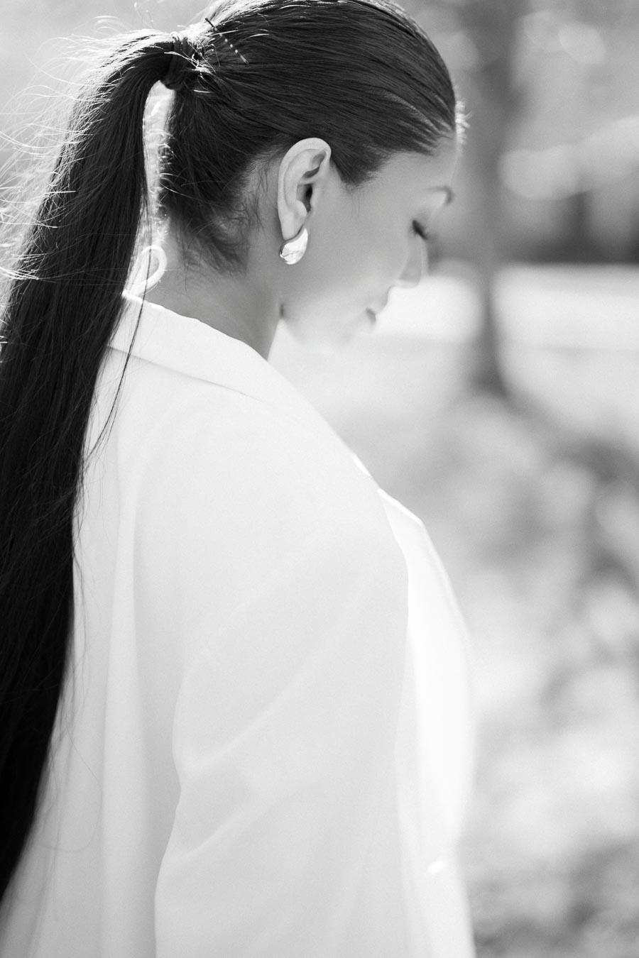 Black and white artistic portrait of a woman with long hair looking down during engagement photoshoot at University of Toronto