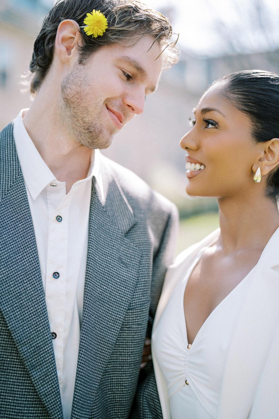 Engaged couple smiling at each other during a spring photoshoot at University of Toronto Trinity College