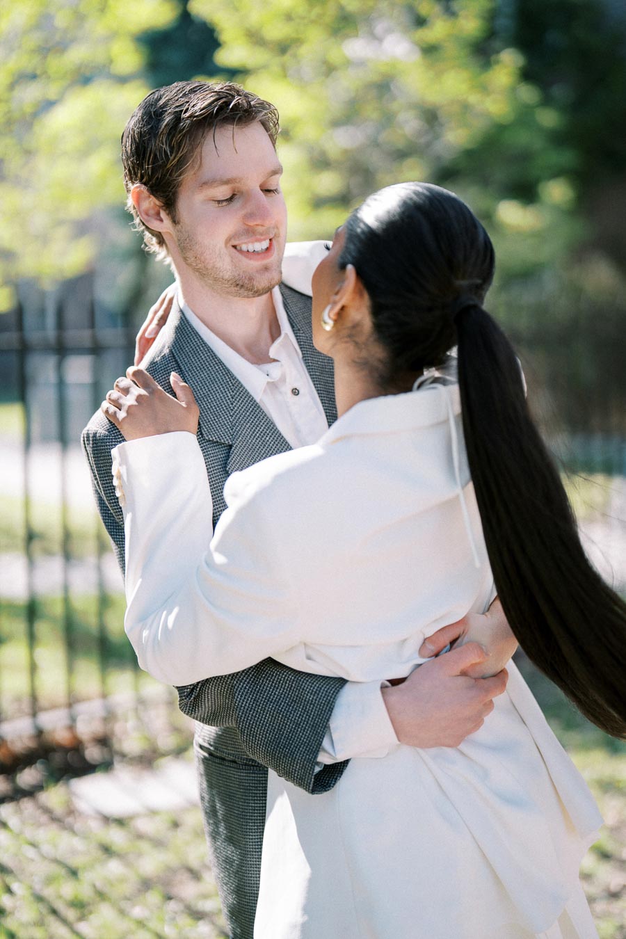 Smiling couple embracing outdoors during spring engagement photoshoot in Toronto