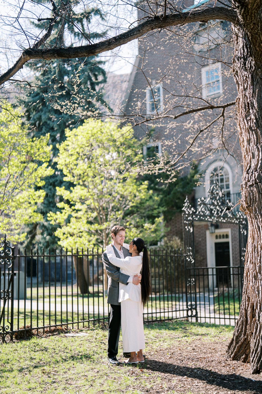 Couple embracing under spring trees during engagement session at University of Toronto