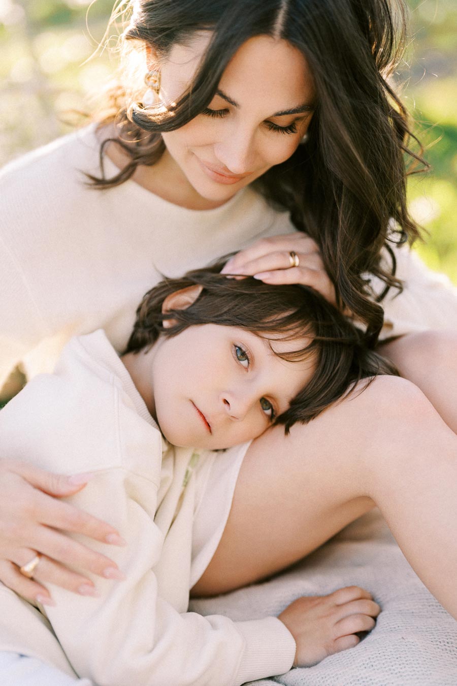 Mother and child resting together in a serene outdoor setting, highlighting tender family bonding and warmth.
