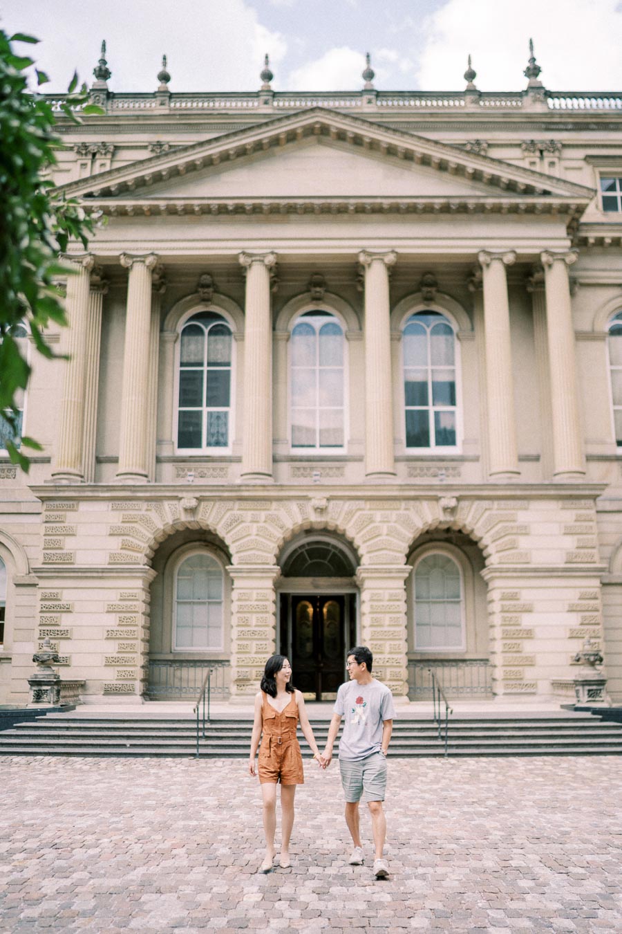 Couple walking hand in hand in front of Osgoode Hall's grand neoclassical façade in Toronto