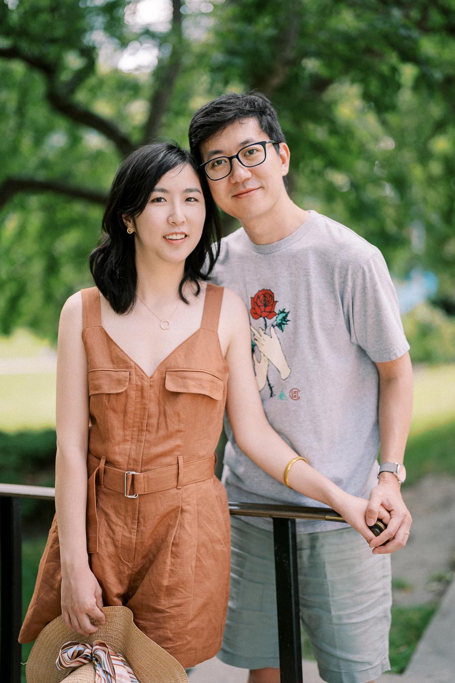 A couple enjoying a day outdoors, with lush greenery in the background.