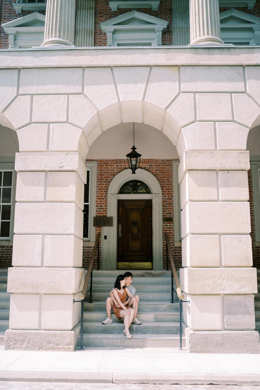 Couple sitting on the stone steps of Osgoode Hall in Toronto, framed by classical architecture