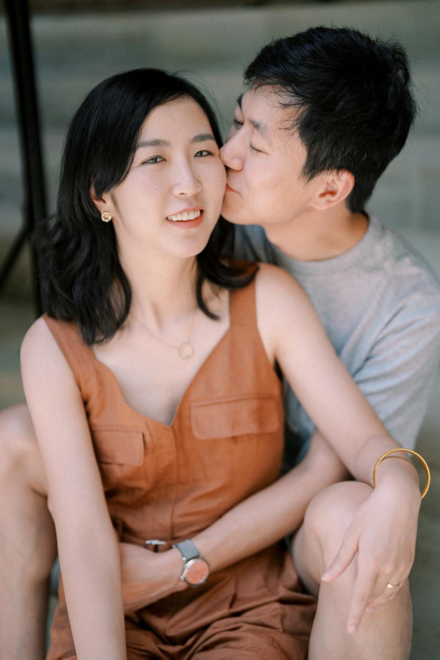 A tender moment between a couple, with the man giving a gentle kiss on the woman's cheek.