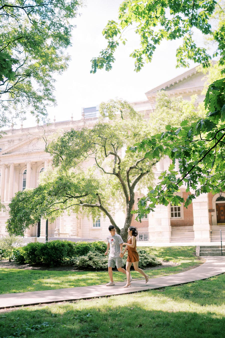 Couple walking and smiling in front of historic Osgoode Hall building in Toronto on a sunny day
