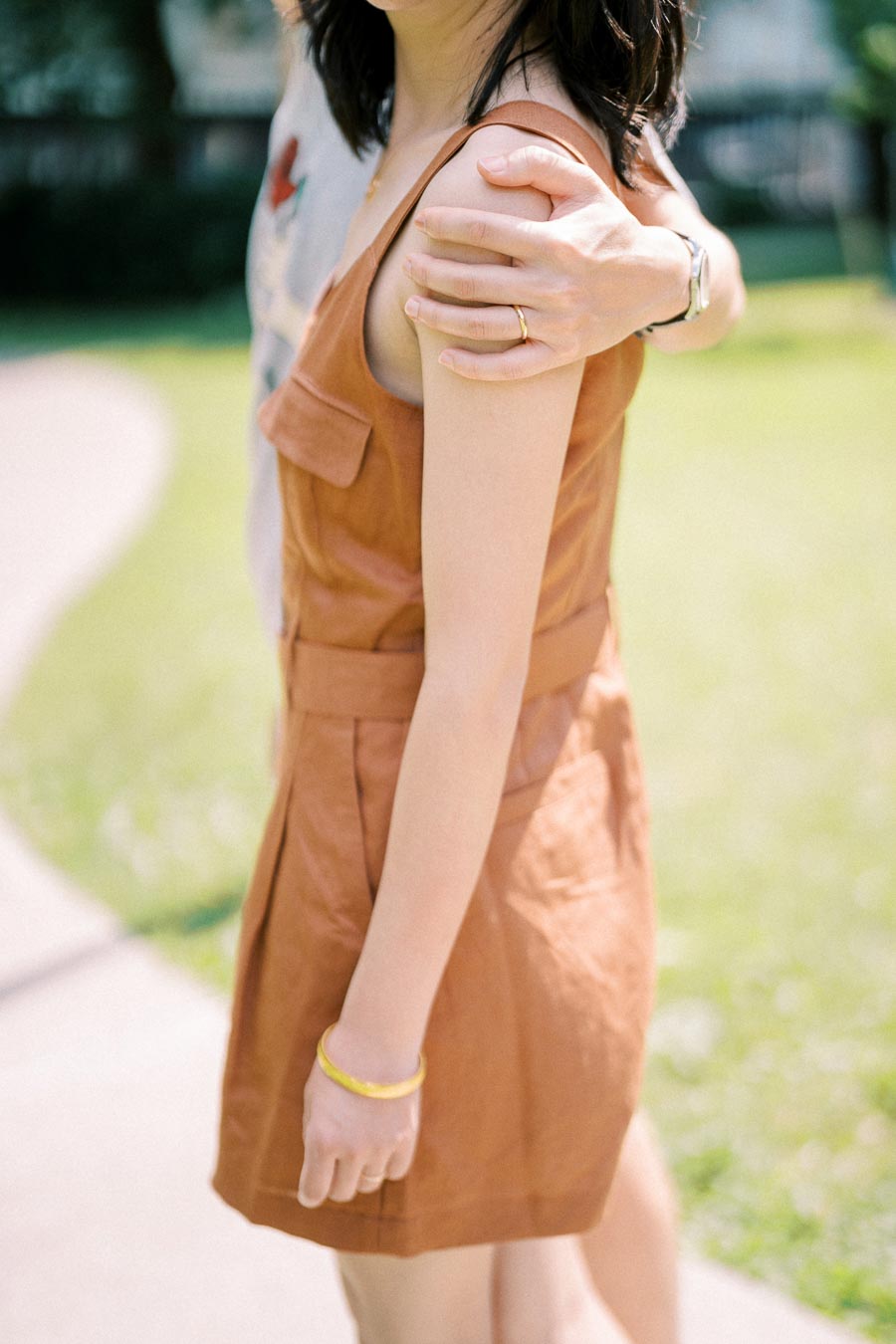 Close-up of a man’s hand gently holding a woman’s shoulder during a summer couple photoshoot in Toronto