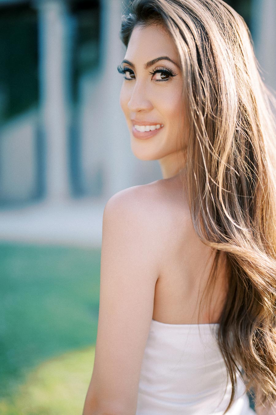 Bride-to-be smiling over shoulder in soft sunlight during engagement session at Parkwood Estate, captured by Toronto photographer