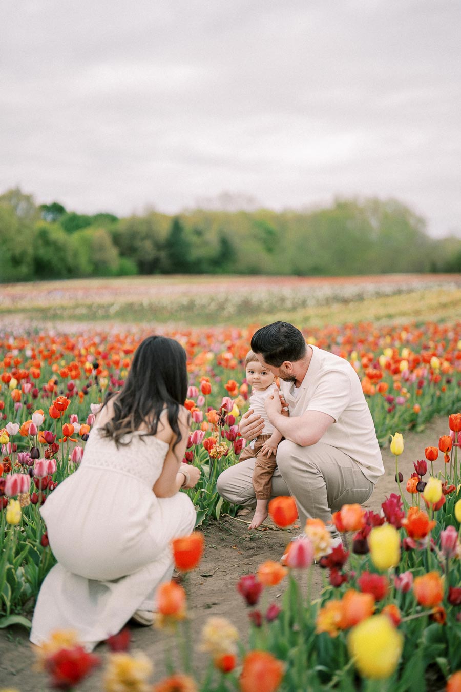 A family enjoying a day in a vibrant tulip field, surrounded by colorful flowers.