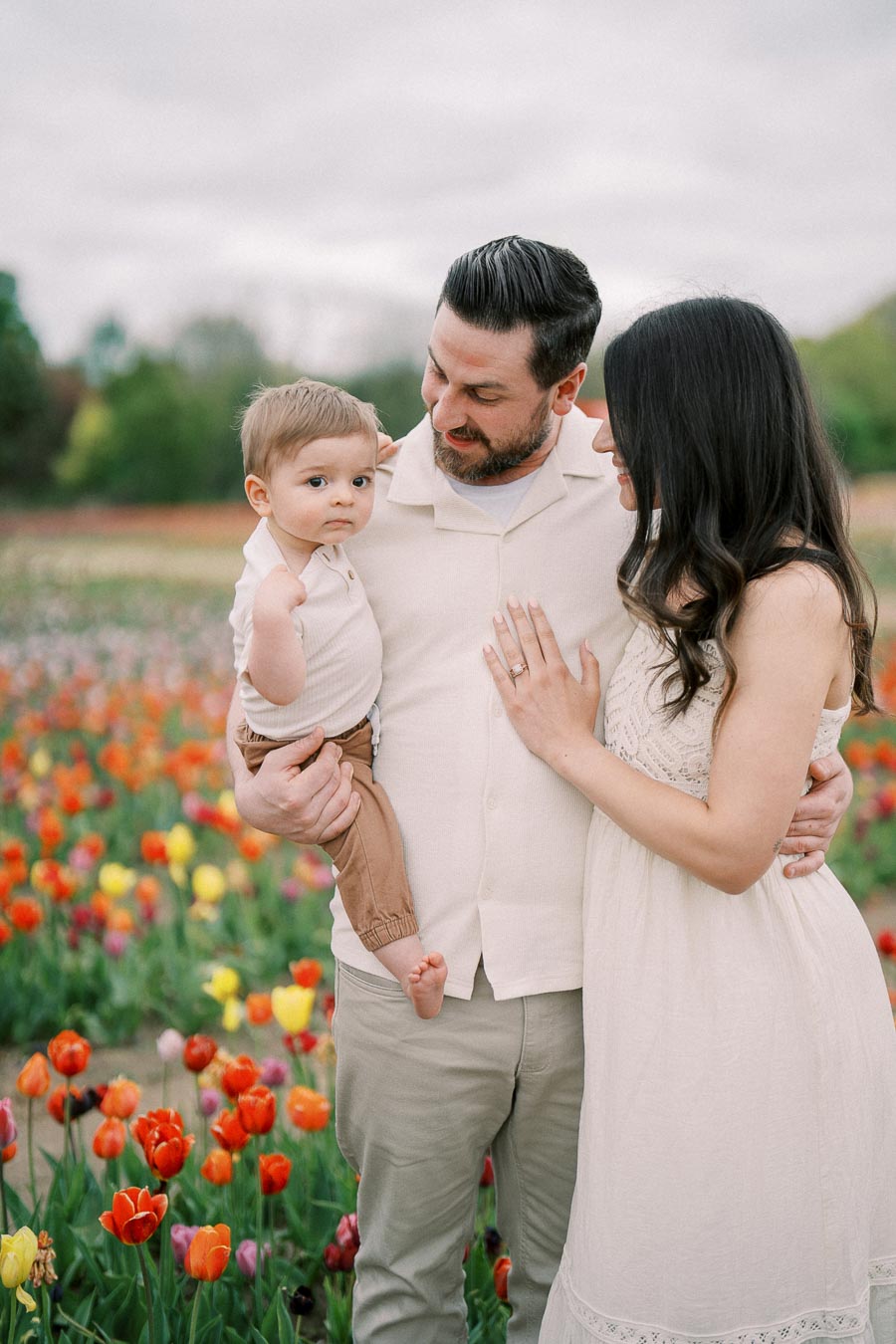 A family enjoys a day out in a vibrant tulip field, capturing a tender moment together.