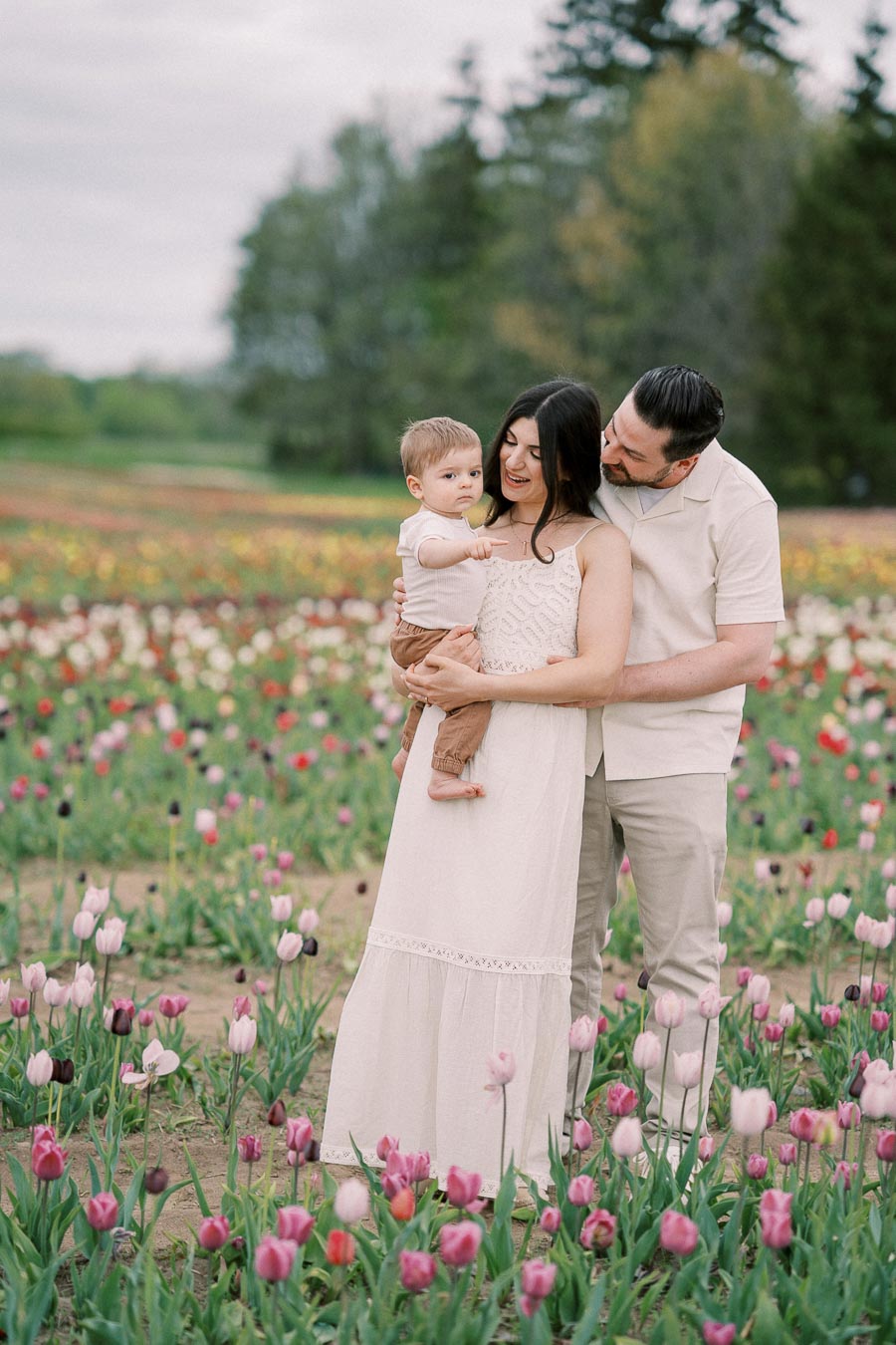 A family enjoys a day out in a vibrant tulip field, capturing a moment of togetherness and joy.
