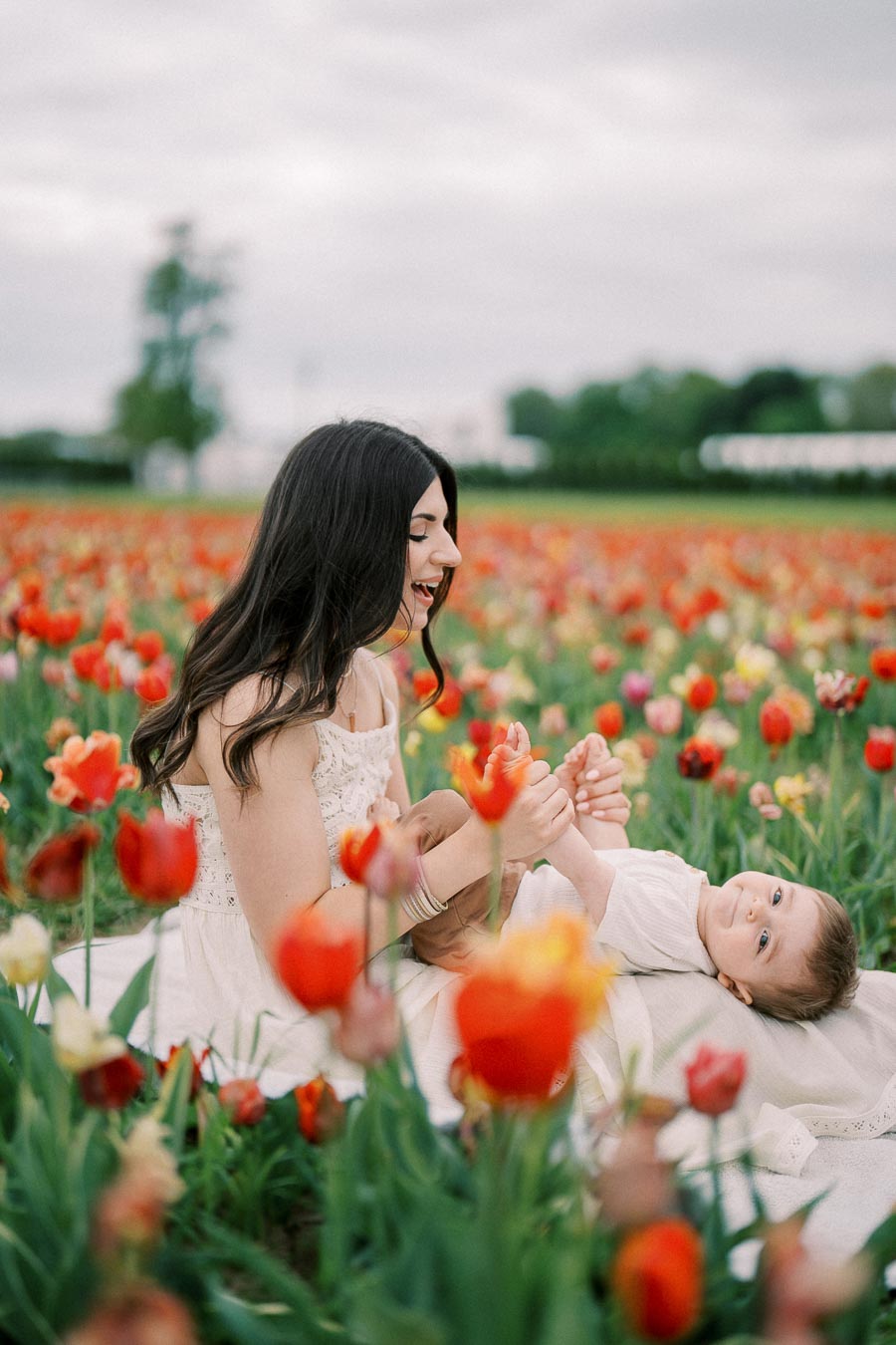 A joyful moment captured between a woman and a child in a vibrant tulip field.
