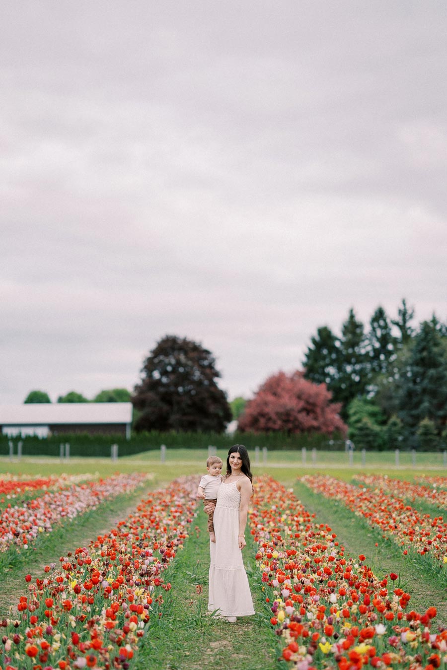 A woman and child enjoying a stroll through a vibrant tulip field.
