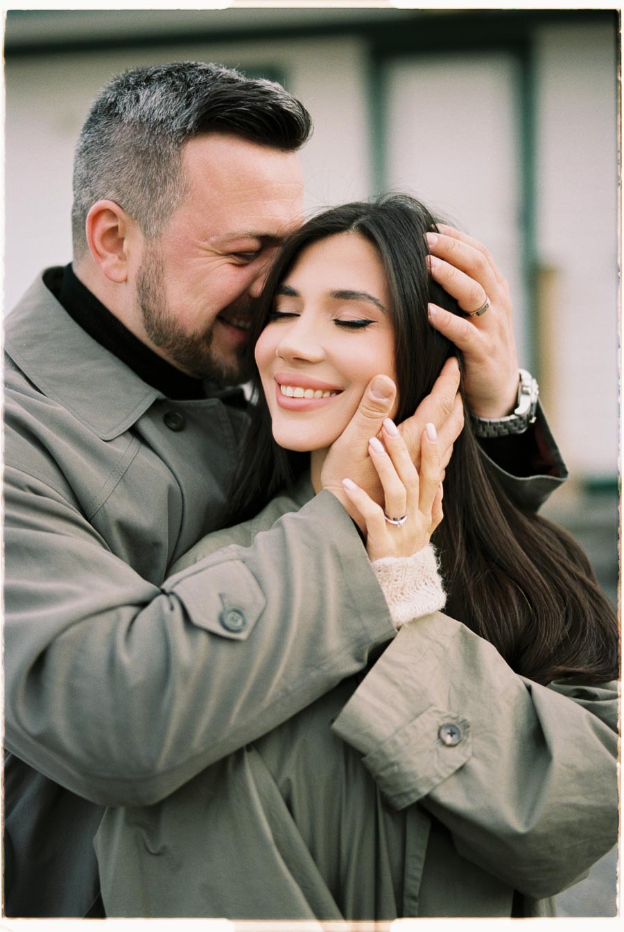 A couple sharing a tender moment, wrapped in each other's arms and smiling warmly.