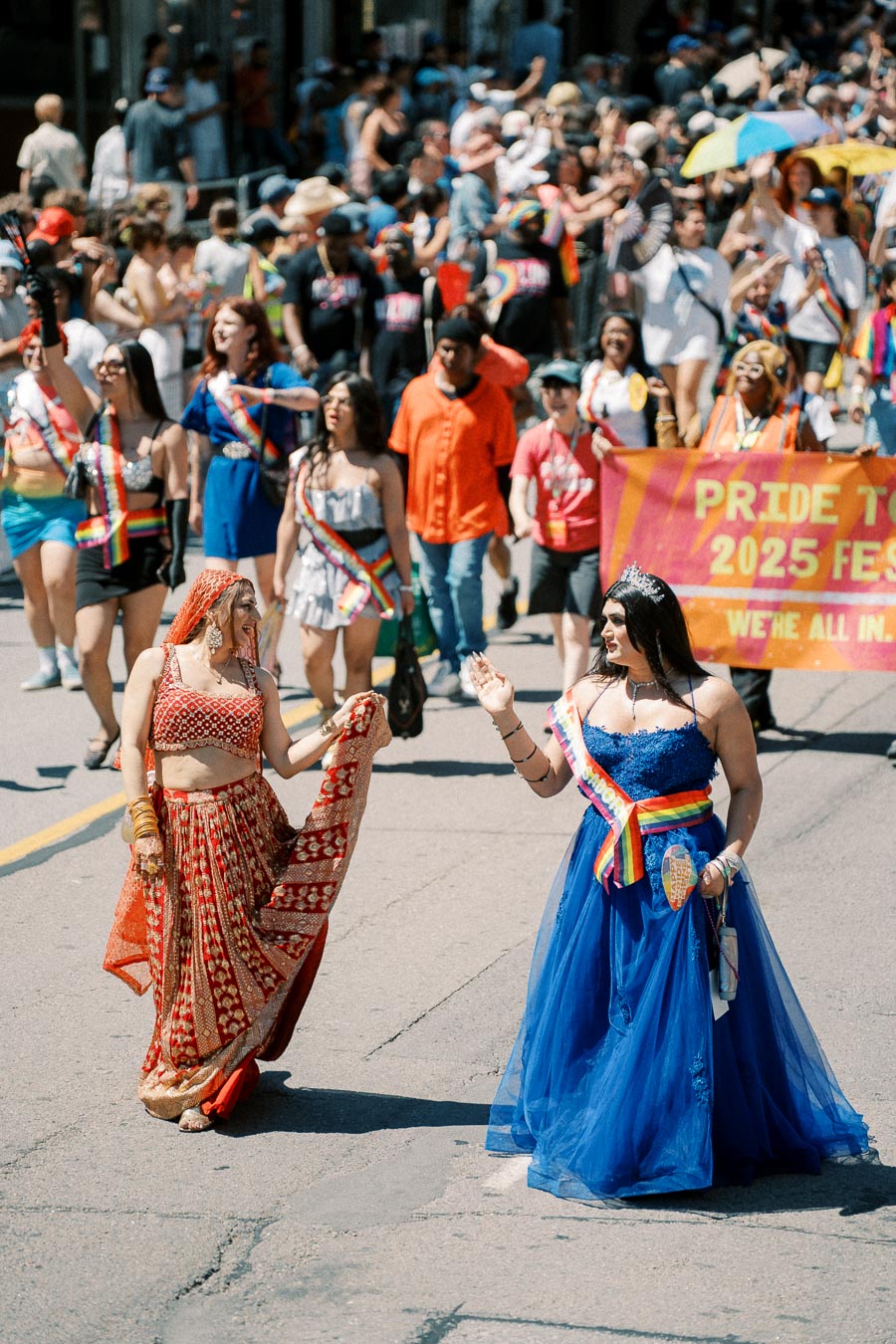 Participants in colorful attire celebrate at the Pride Toronto 2025 Festival parade, showcasing diversity and inclusion.
