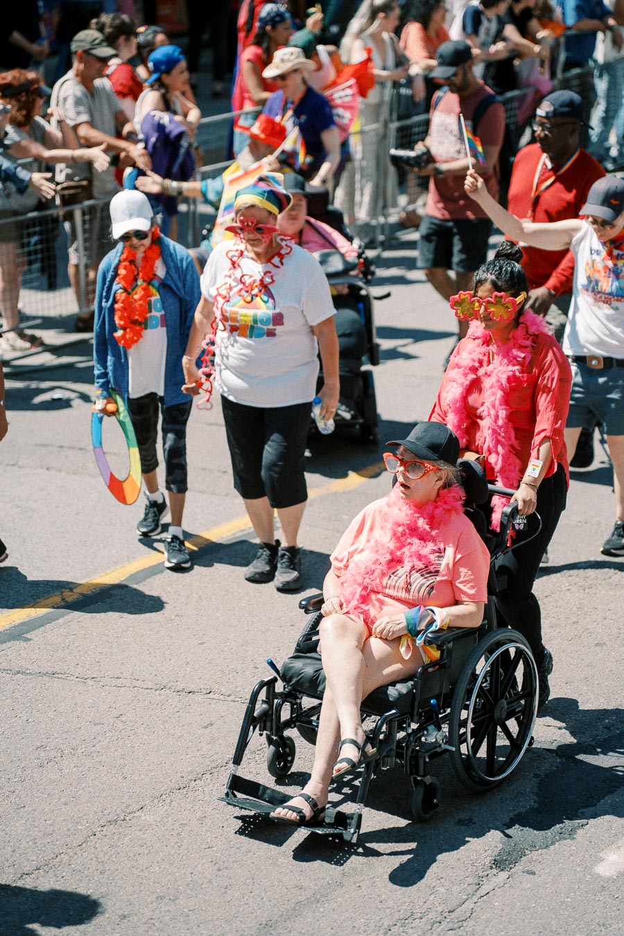 Participants in a pride parade, adorned with colorful accessories, celebrate inclusivity and diversity.