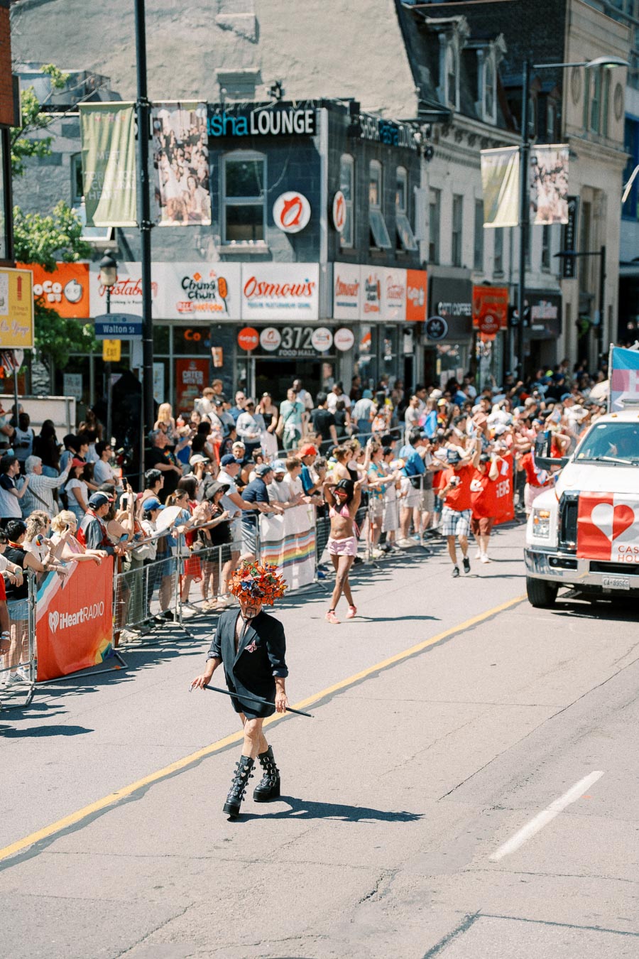 A vibrant parade scene with participants and spectators enjoying the event on a sunny day.