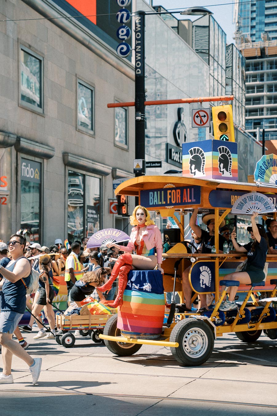 A lively street parade featuring a colorful float with participants celebrating in vibrant attire.